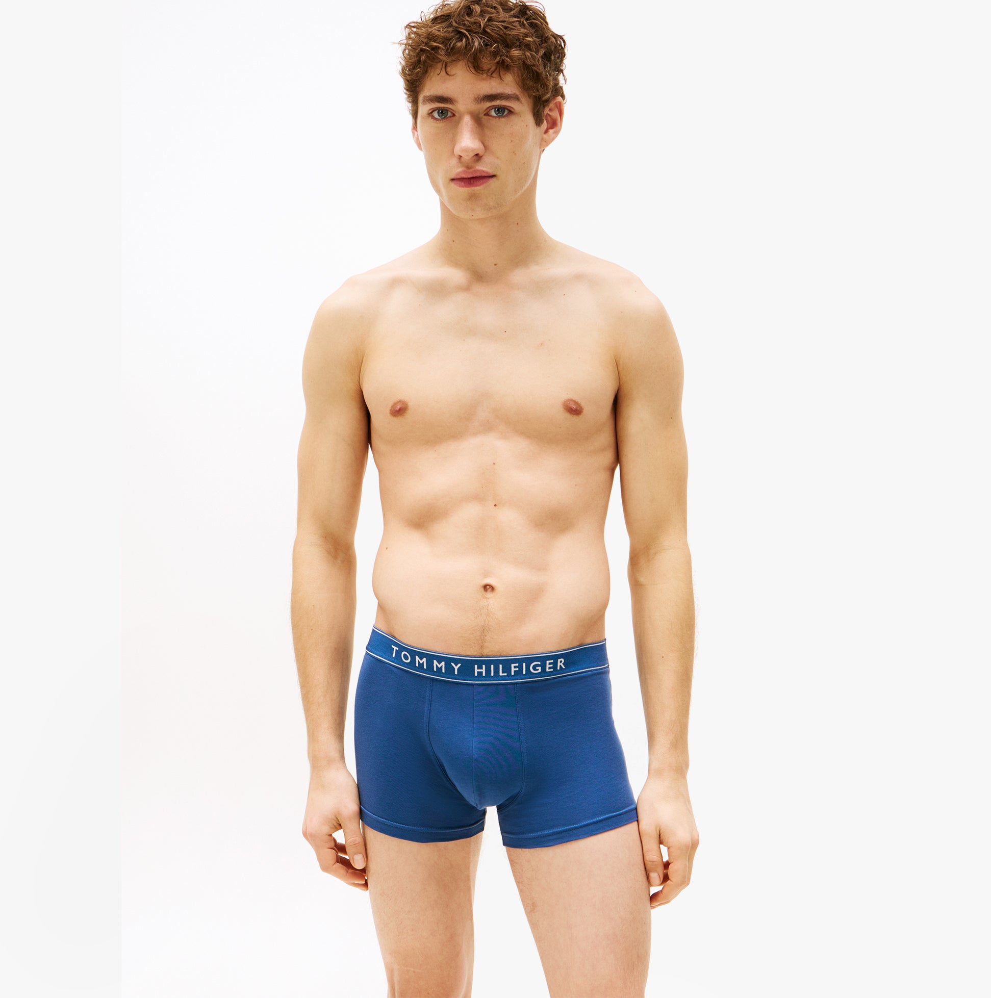 Tommy Hilfiger 3 Pack Mens Trunks Des Sky/Calico/Fssl Blue front view on model, showcasing stretch cotton fabric and logo waistband.
