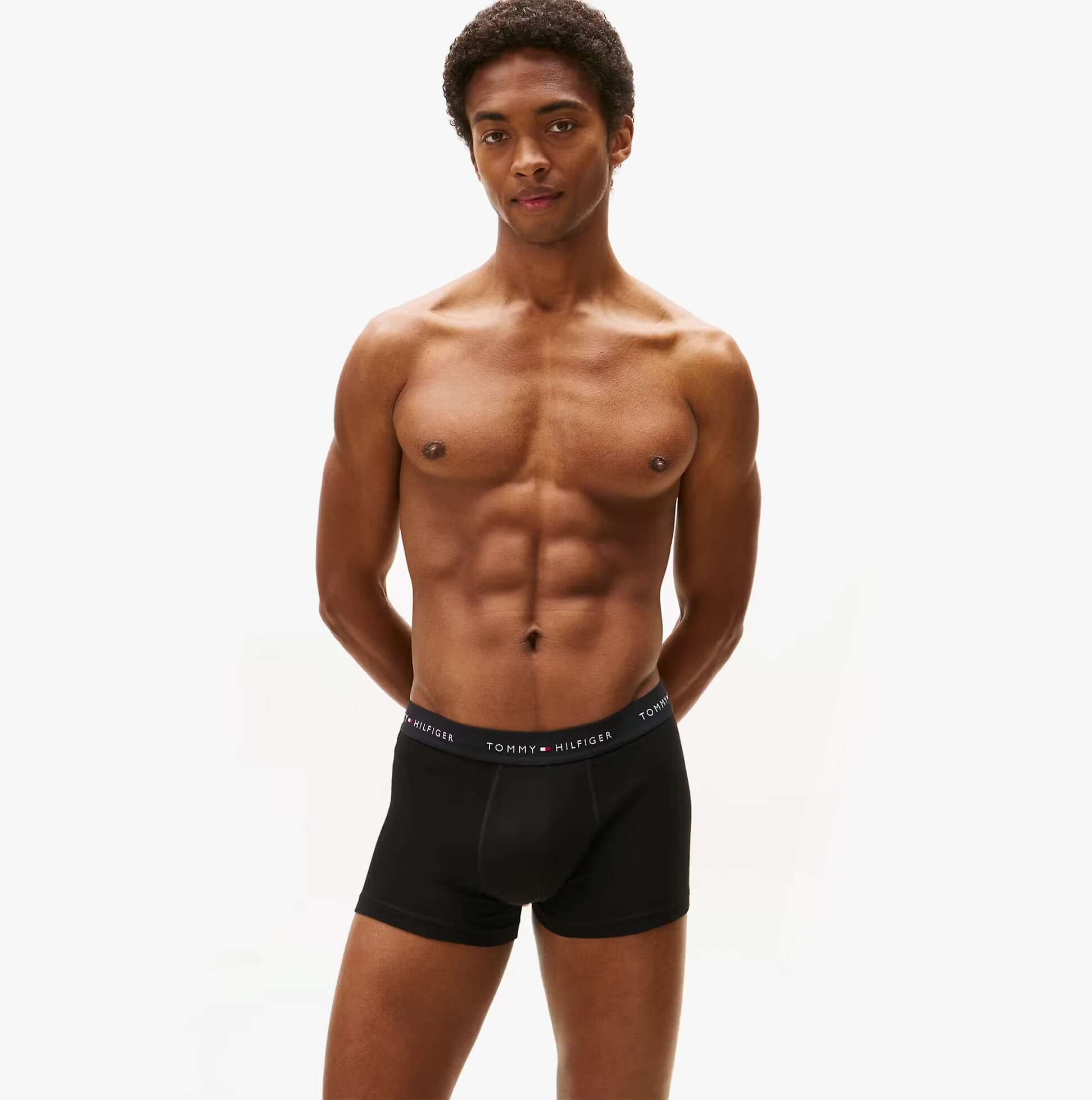 Tommy Hilfiger Mens 3 Pack Logo Waistband Cotton Trunks Multi front view on model, showcasing black trunk design with logo waistband.
