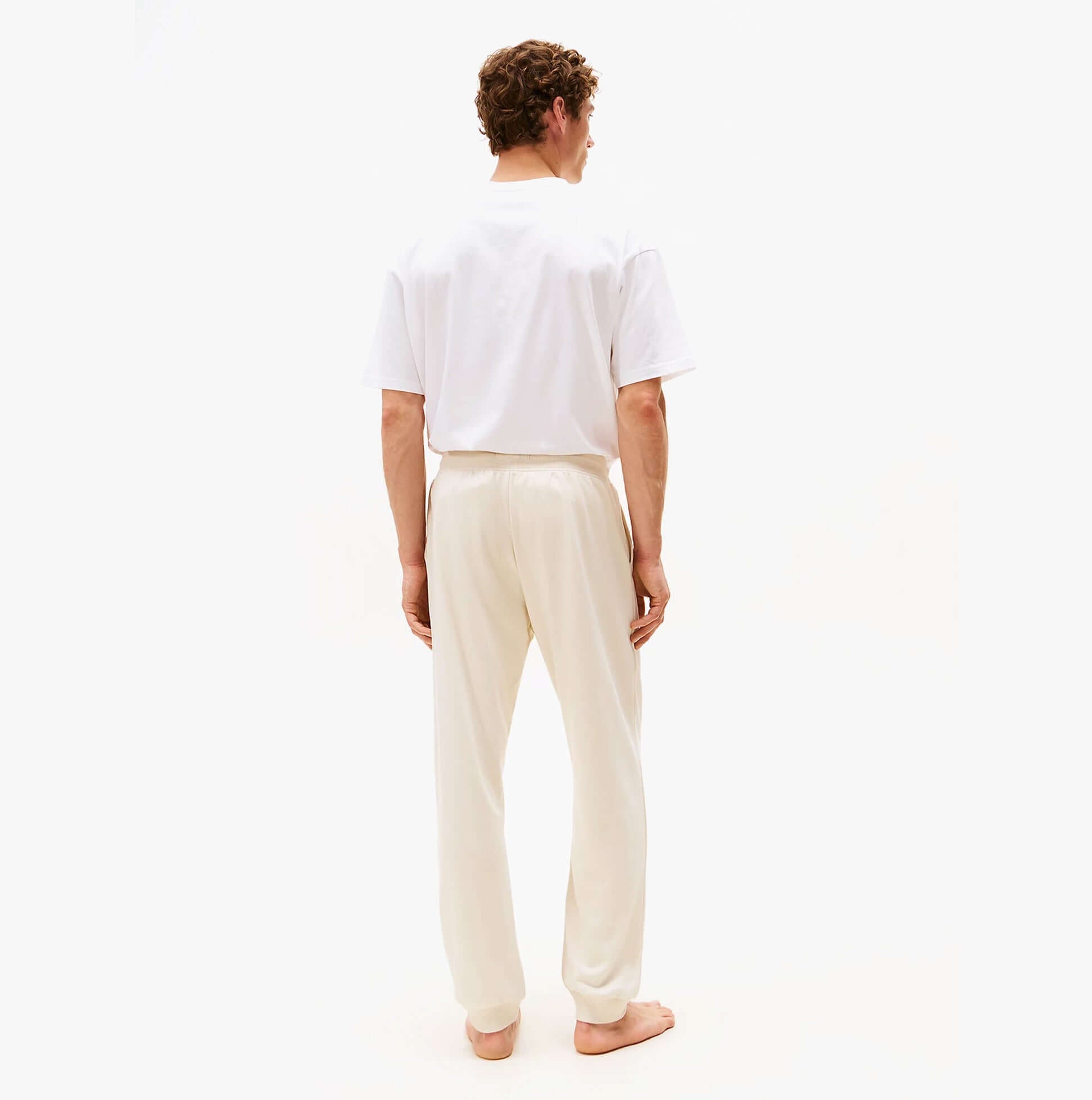 Tommy Hilfiger TH Original Mens Logo Lounge Joggers Off White Newsprint back view, model wearing casual joggers.