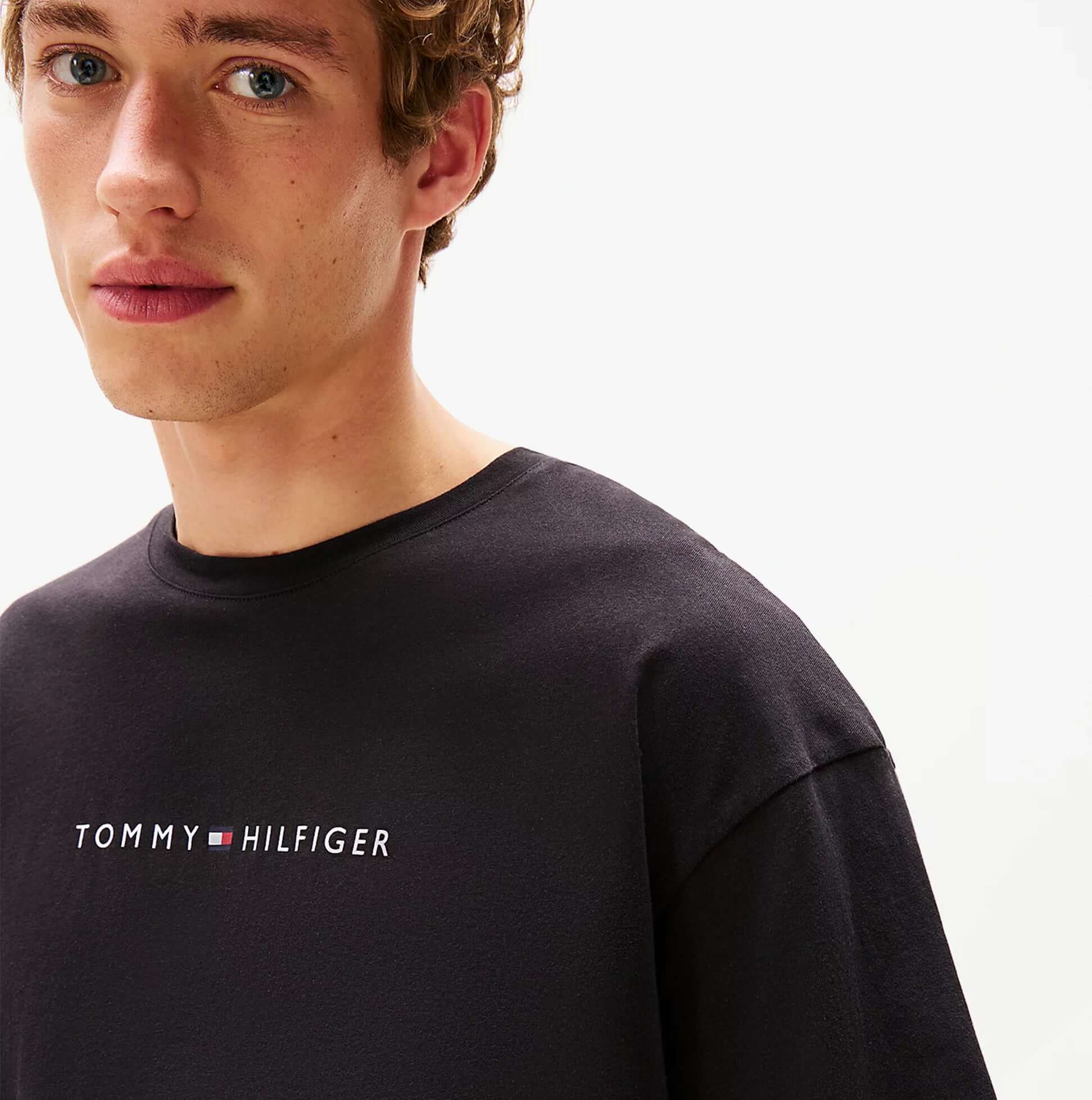 Tommy Hilfiger LOGO T-Shirt Mens Black detail view of logo on a black shirt model wearing it