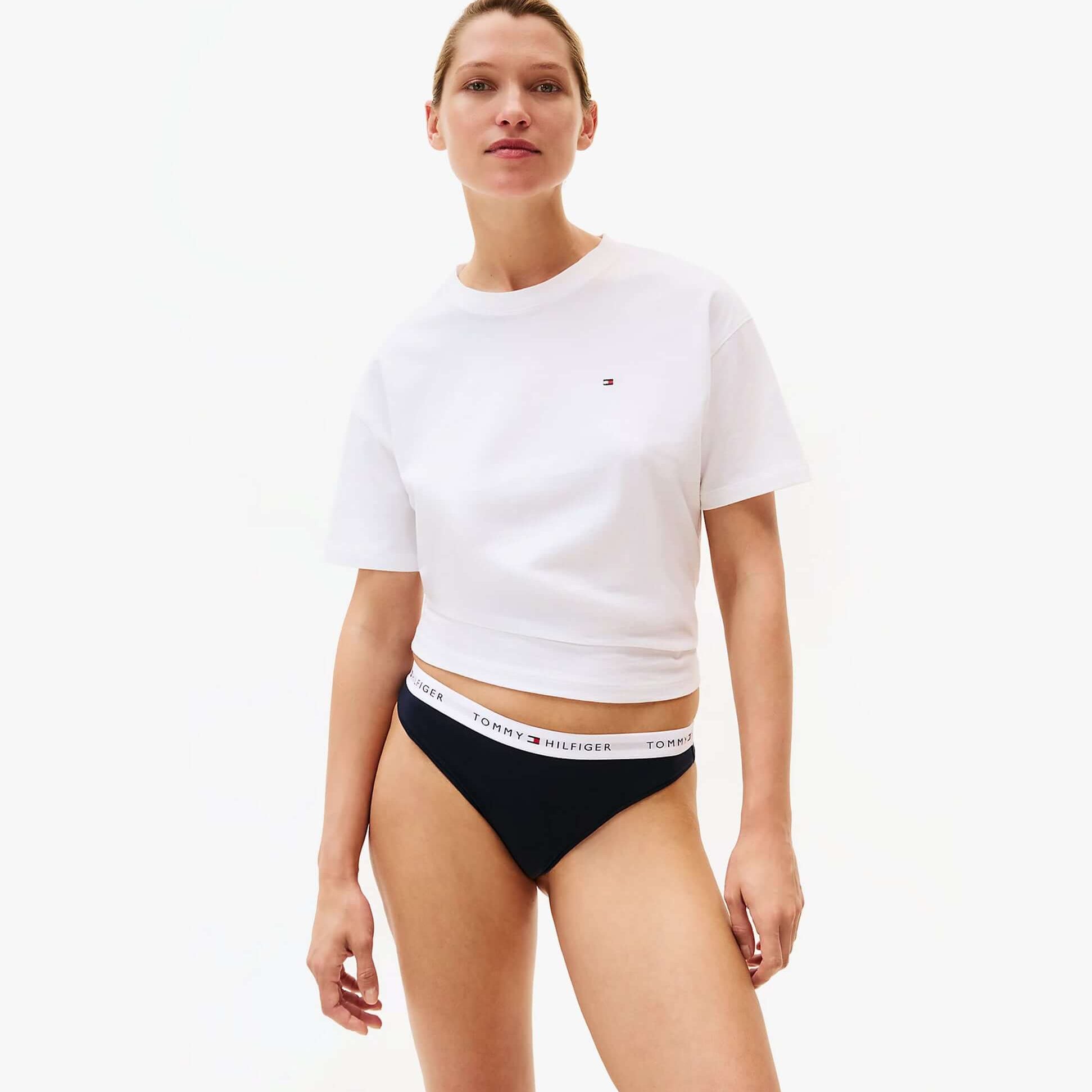 Tommy Hilfiger Womens 3 PACK THONG Multi front view of model wearing white crop top and black thong.