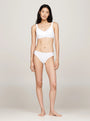 Tommy Hilfiger MONOTYPE Womens Thong White front view worn by model, showcasing ribbed texture and elasticated waistband.