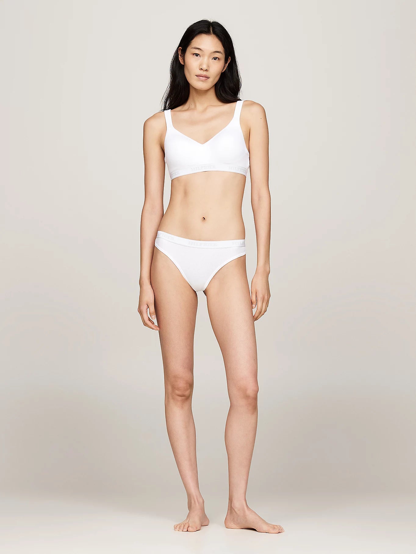 Tommy Hilfiger MONOTYPE Womens Thong White front view worn by model, showcasing ribbed texture and elasticated waistband.