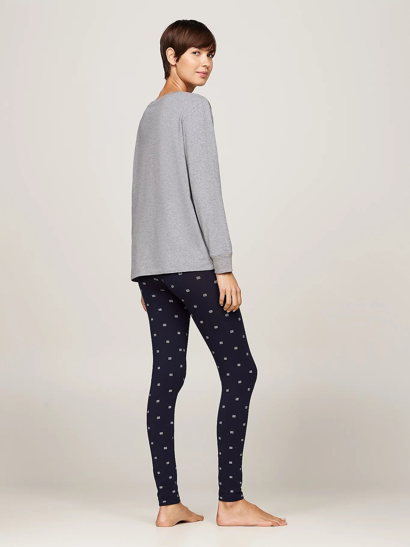 Tommy Hilfiger ORIGINAL Womens Legging Pyjama & Eye Mask Gift Set side view, model wearing grey top and navy patterned leggings.