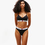 Tommy Hilfiger HERITAGE Womens Padded Push-Up Bralette Black front view on model with curly hair wearing matching black underwear.