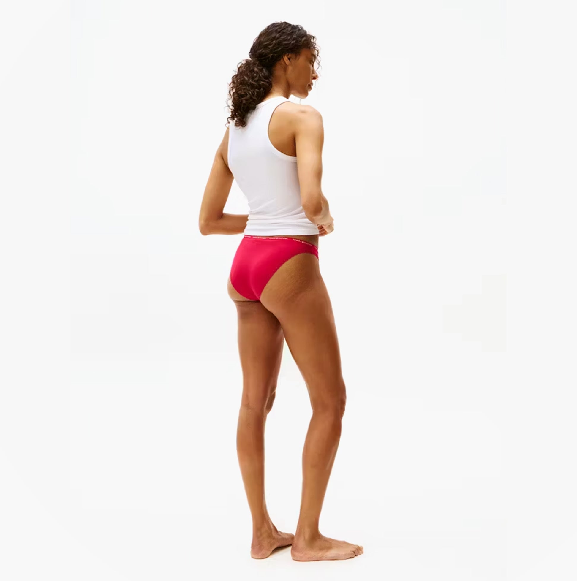 Tommy Hilfiger Womens 3 Pack Lace Trim Bikini Brief Multicolour side view on a model wearing a white tank top and red bikini briefs.