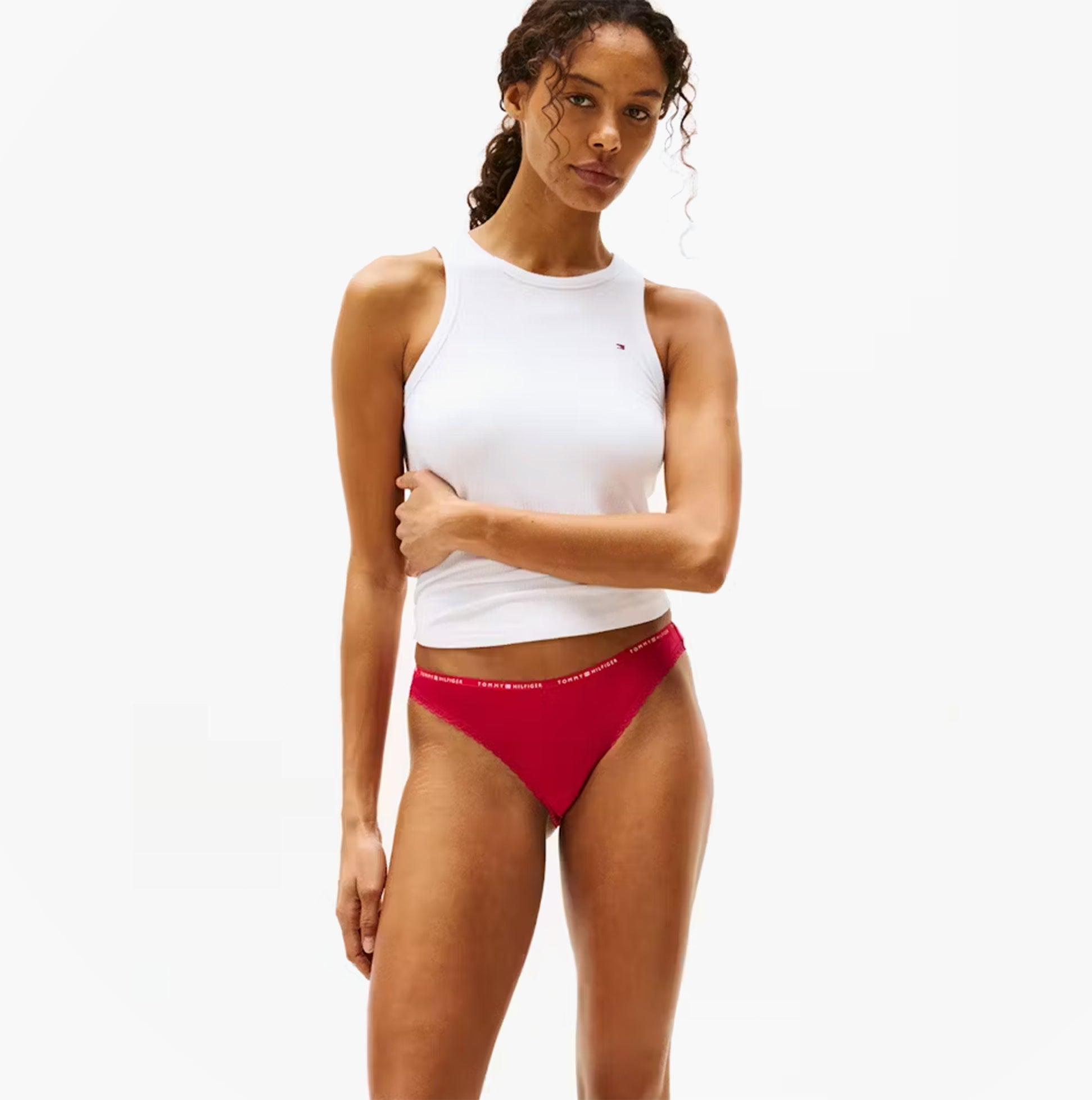 Tommy Hilfiger Womens 3 Pack Lace Trim Bikini Brief Multicolour side view model wearing red bikini and white tank top.