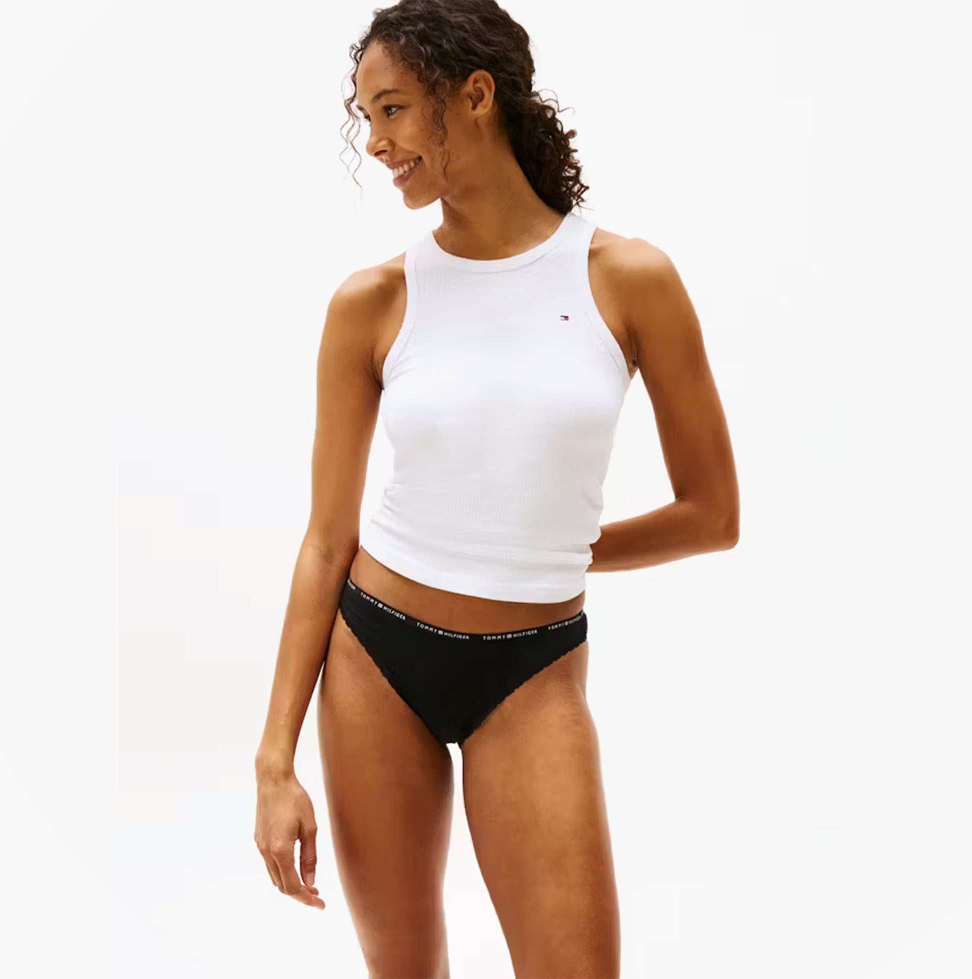 Tommy Hilfiger Womens 3 Pack Lace Trim Bikini Brief Multicolour side view of model wearing black bikini brief and white top.