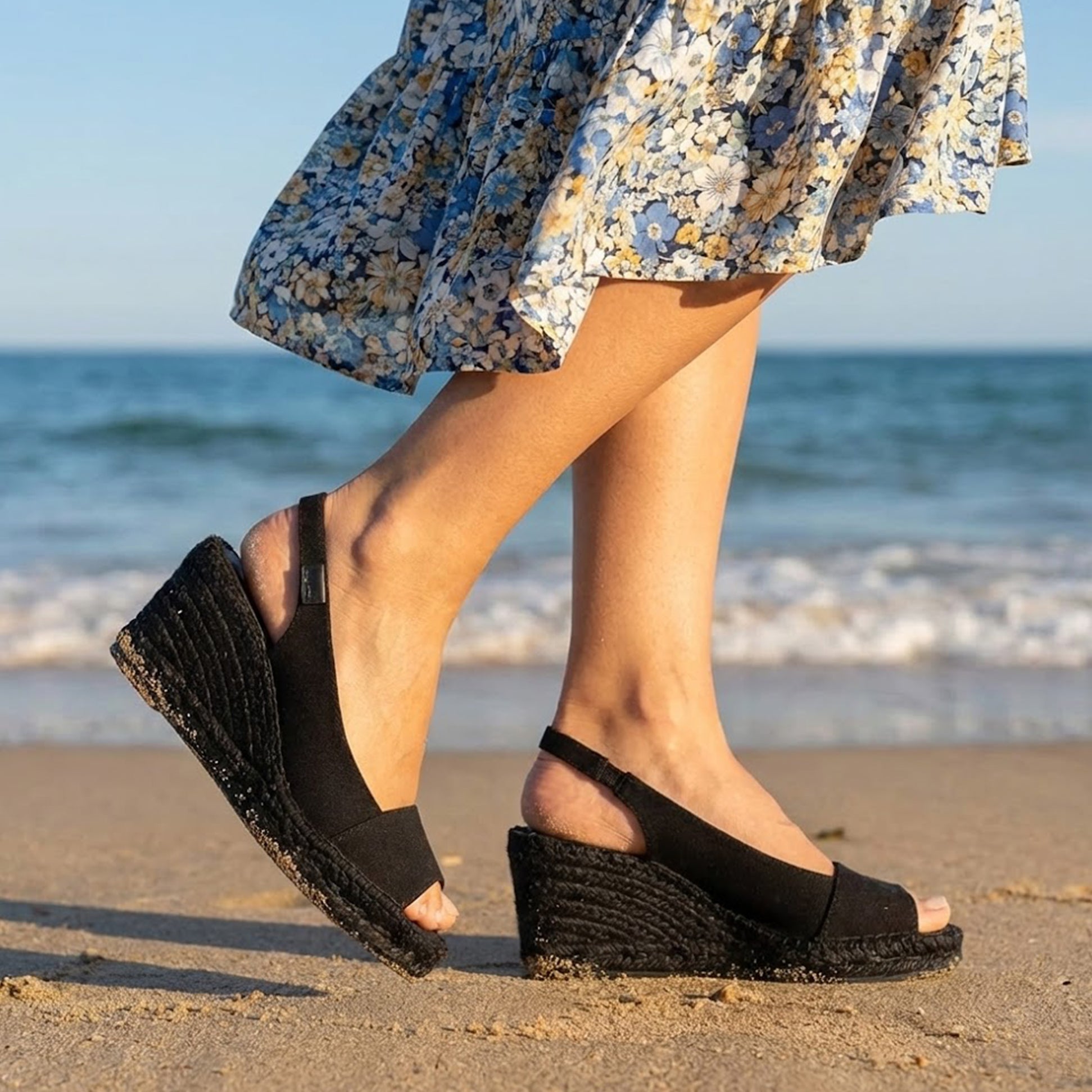 Toni Pons FIORE Womens Sandals Black side view on the beach, showcasing wedge heel and stylish design.