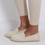 Totes Isotoner TEXTURED Womens Moccasin Slippers Beige worn in side view with light beige pants.