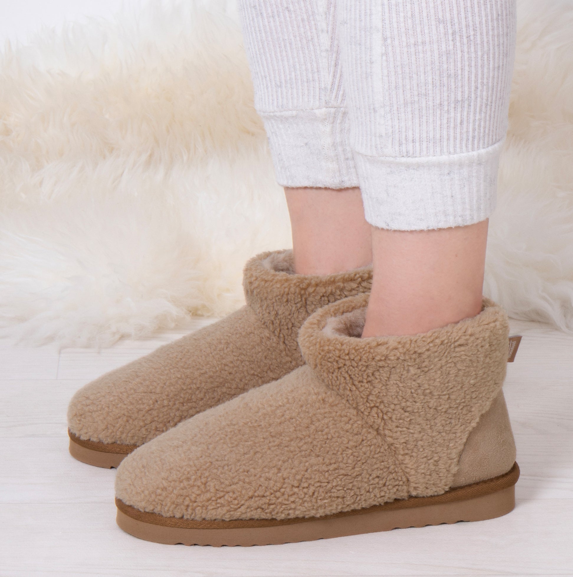 Totes Isotoner CURLY FUR BOOT Womens Bootie Slippers Natural side view showing cozy curly fur design and soft textile lining.