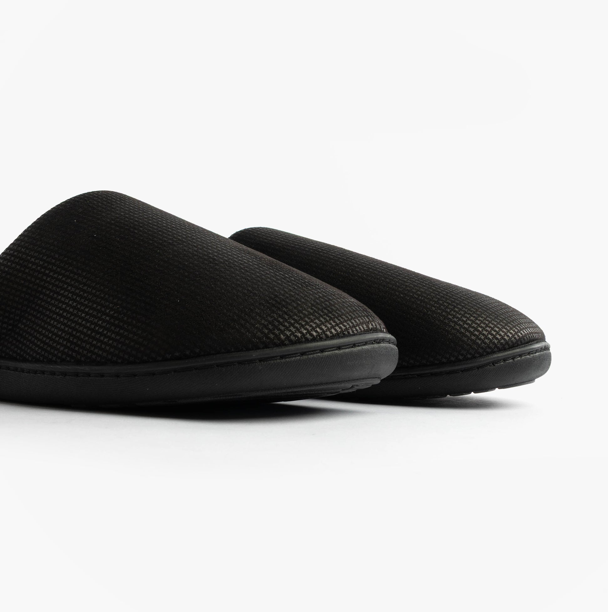 Totes Isotoner SQUARE PATTERNED SMART MULE Mens Mule Slippers Black side view showing textured upper and rounded toe.