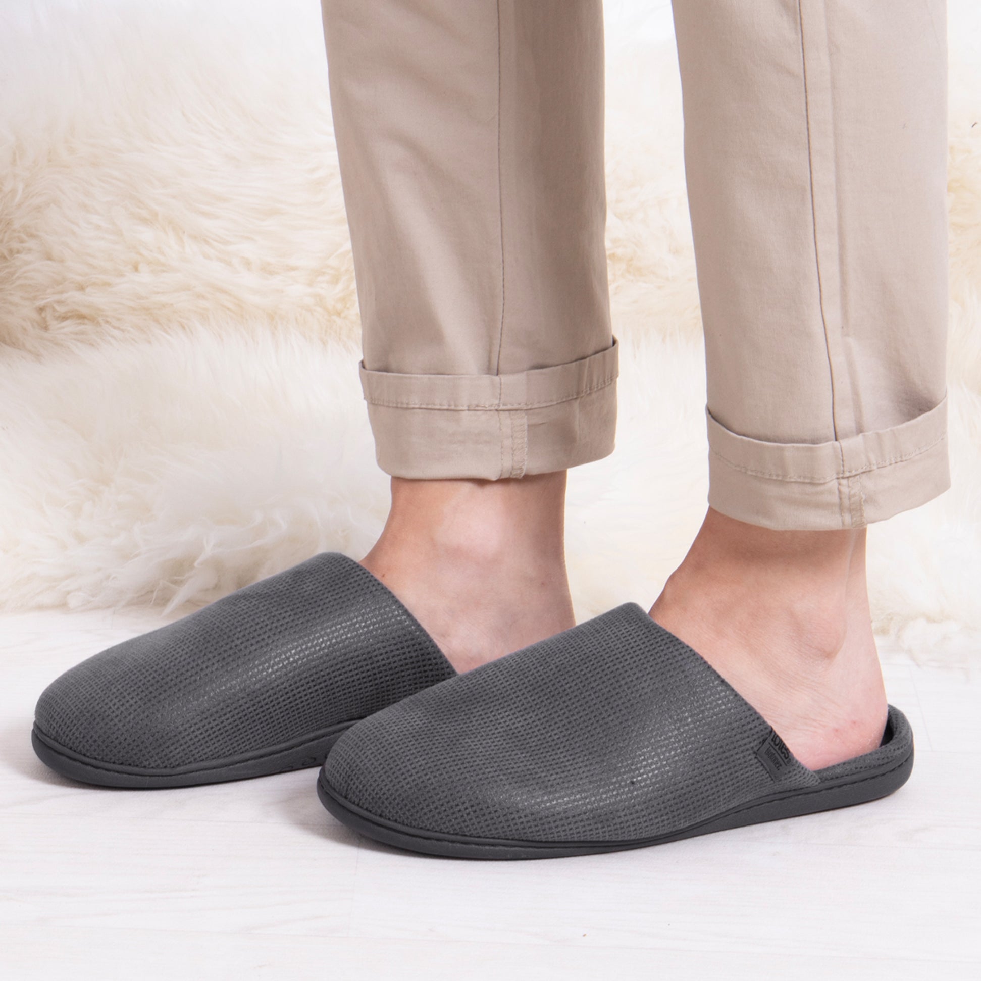 Totes Isotoner SQUARE PATTERNED SMART MULE Mens Mule Slippers Grey side view of slippers worn with beige pants.