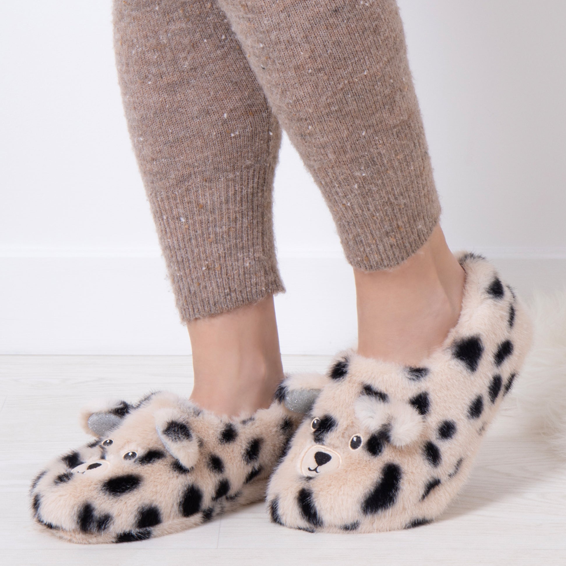 Totes Toasties NOVELTY FAUX FUR Slippers Womens Dalmatian side view on model's feet with cozy outfit.