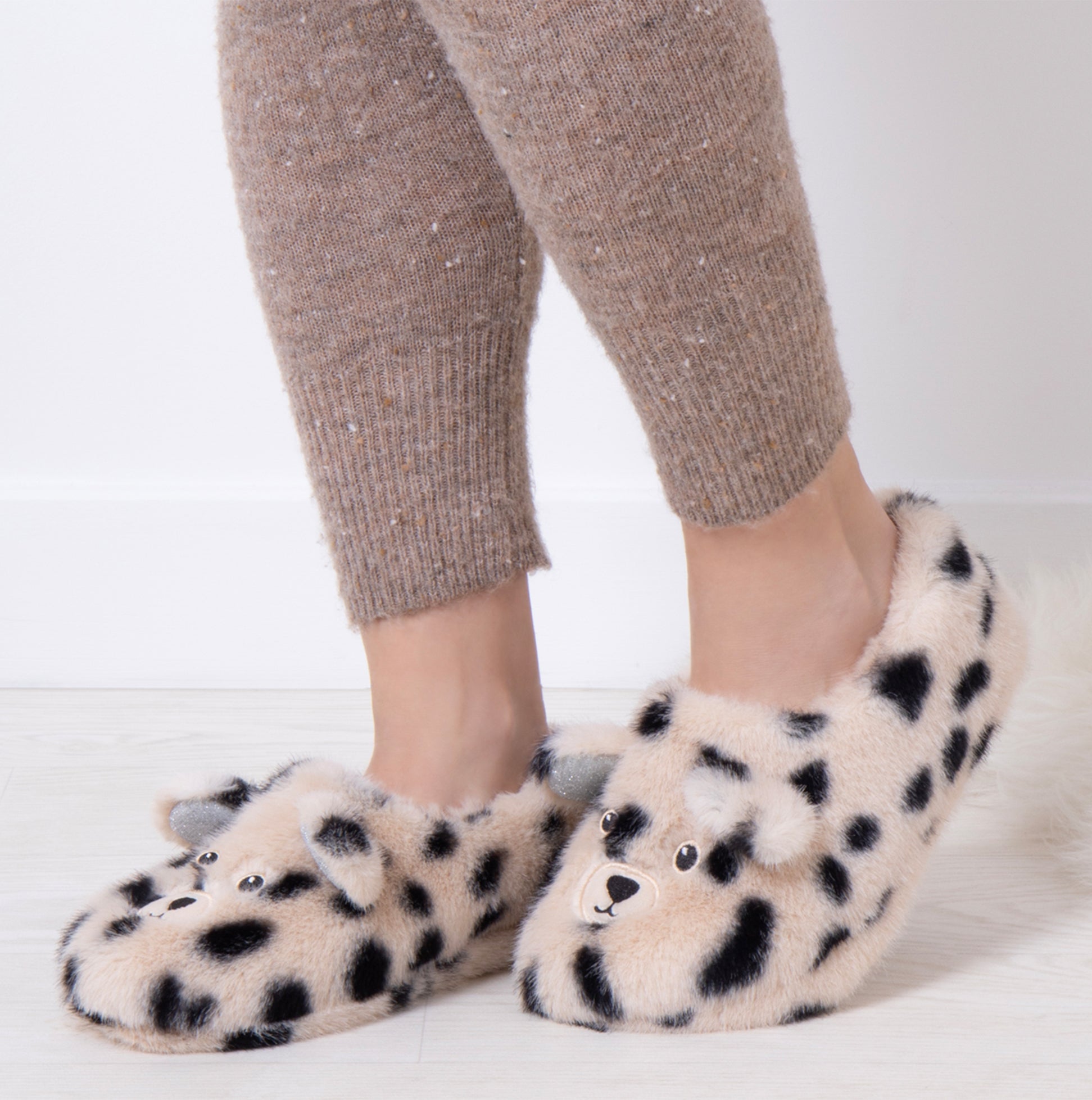 Totes Toasties NOVELTY FAUX FUR Slippers Womens Dalmatian side view on model's feet with cozy outfit.