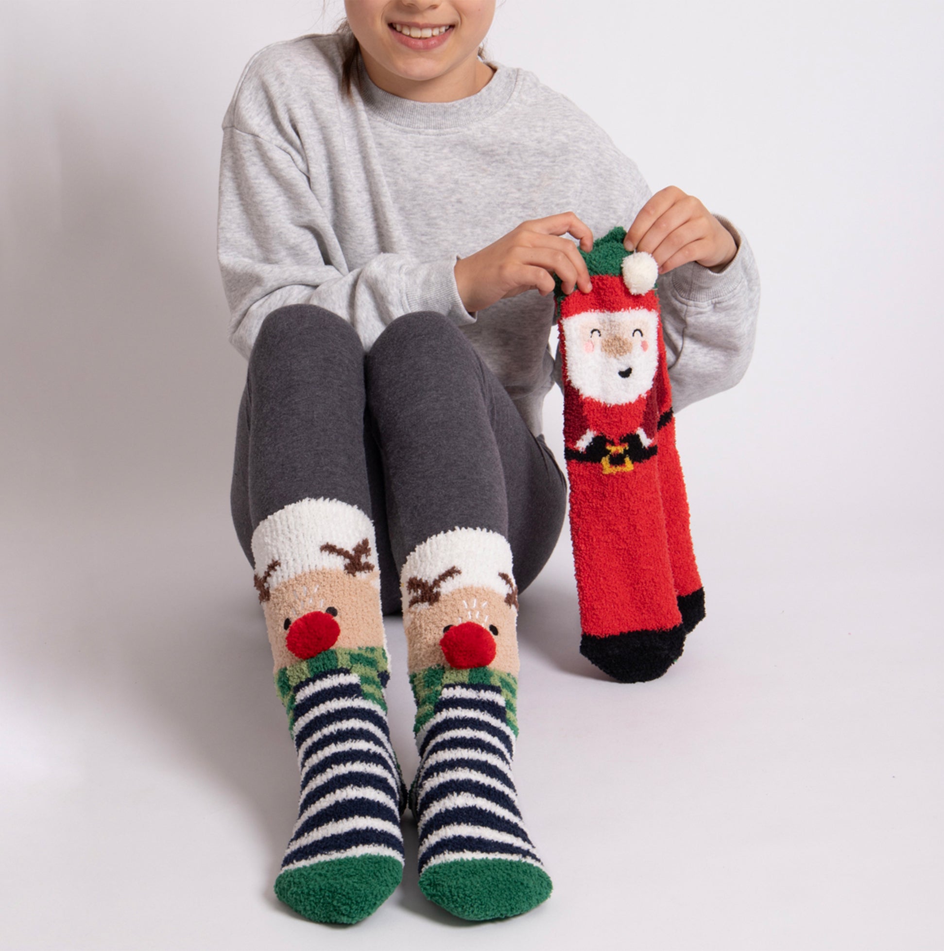 Totes Toasties SUPER SOFT SLIPPER SOCKS (TWIN PACK) Unisex Kids Socks Reindeer / Santa front view on child, showing festive designs.