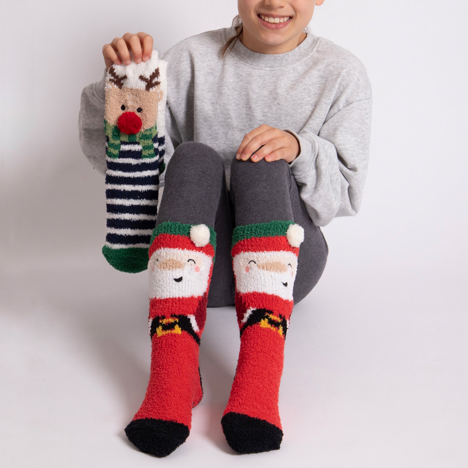 Totes Toasties SUPER SOFT SLIPPER SOCKS (TWIN PACK) Unisex Kids Socks Reindeer / Santa front view with model wearing socks.