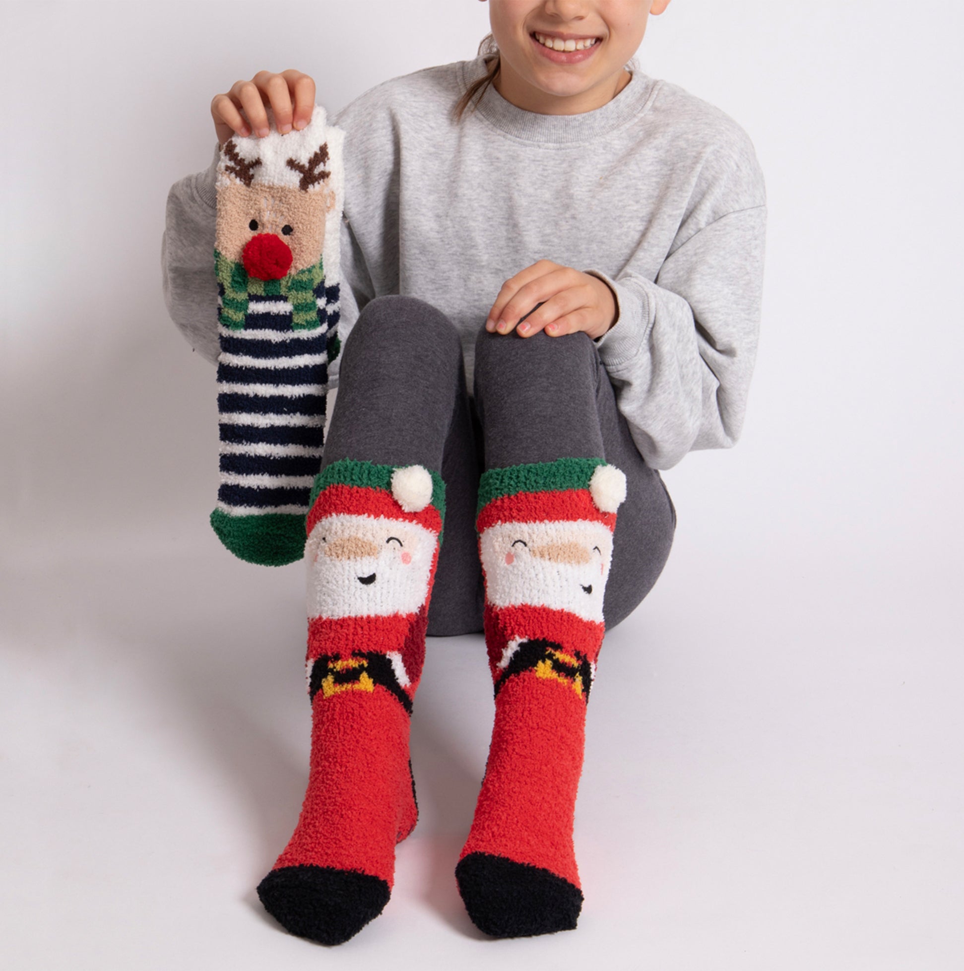 Totes Toasties SUPER SOFT SLIPPER SOCKS (TWIN PACK) Unisex Kids Socks Reindeer / Santa front view with model wearing socks.
