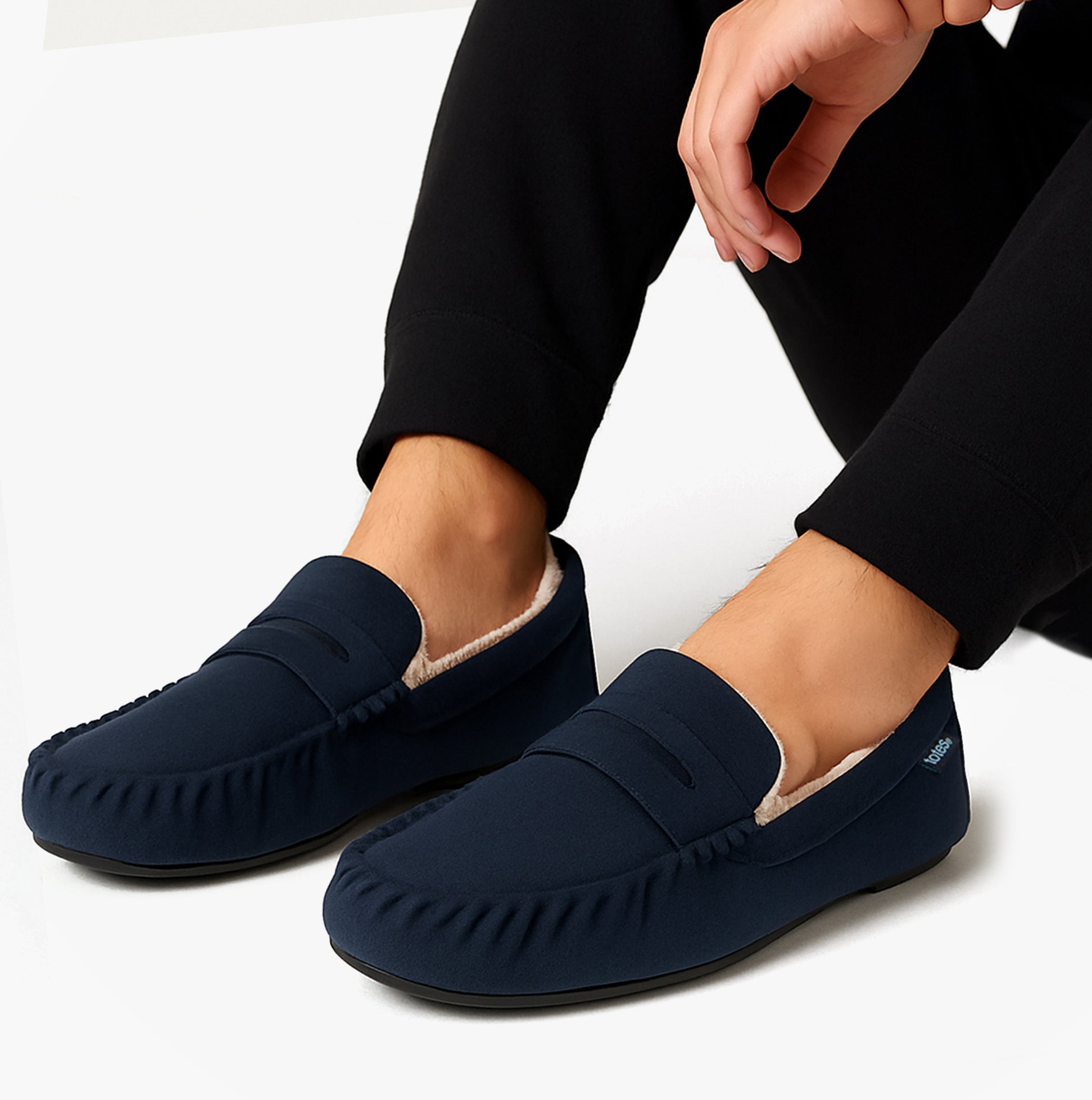 Totes Toasties SUEDETTE Moccasin Slippers Mens Navy side view worn by a man, showcasing comfort and faux fur lining.