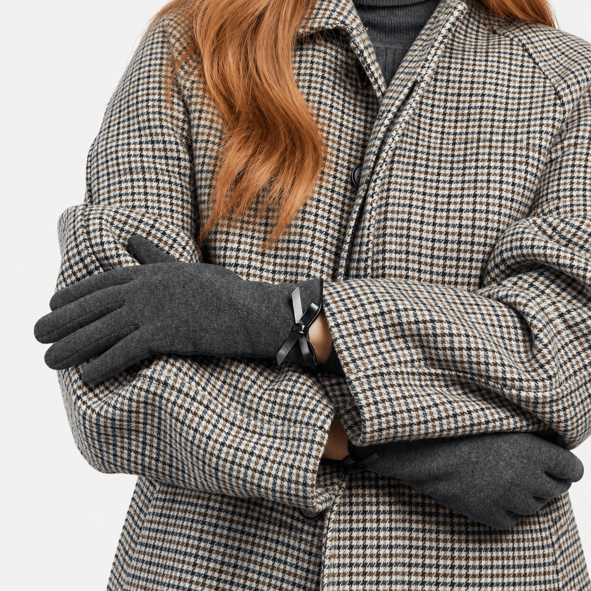Totes Isotoner THERMAL GLOVE WITH BOW DETAIL Womens Touchscreen Gloves Grey worn by a woman in a stylish coat.