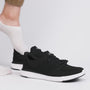 Kizik LIMA Unisex Adults Trainers Black side view with a foot wearing a sock, showcasing casual knit upper and rubber sole.